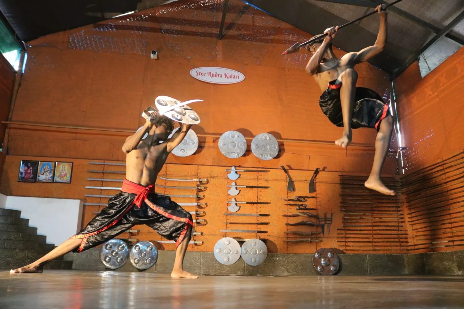 Two students in a mid-air spear and shield bout at Sree Rudra Kalari, Tripunithura