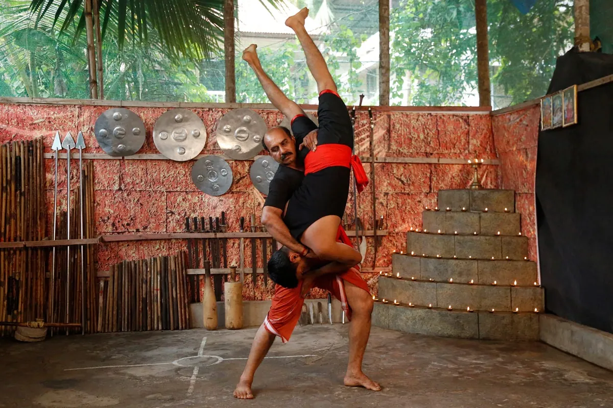 A kalari master lifting a student into a throw during partner practice at Sree Rudra Kalari, Tripunithura